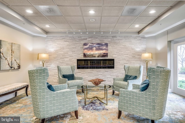 sitting room featuring track lighting, a healthy amount of sunlight, and a fireplace