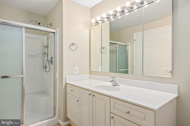 bathroom with a shower stall and vanity