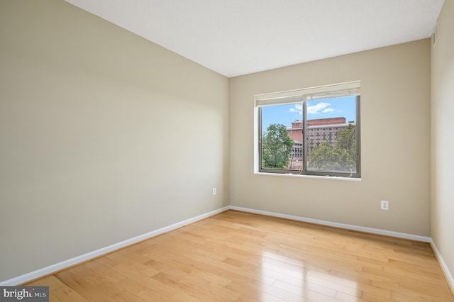 empty room featuring light wood-type flooring and baseboards