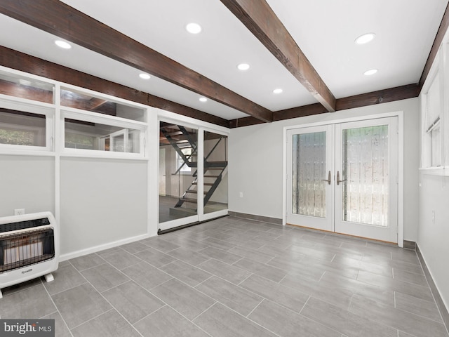 unfurnished living room featuring heating unit, beamed ceiling, baseboards, stairway, and french doors