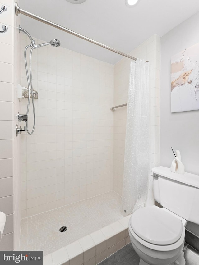 full bathroom with a stall shower and toilet