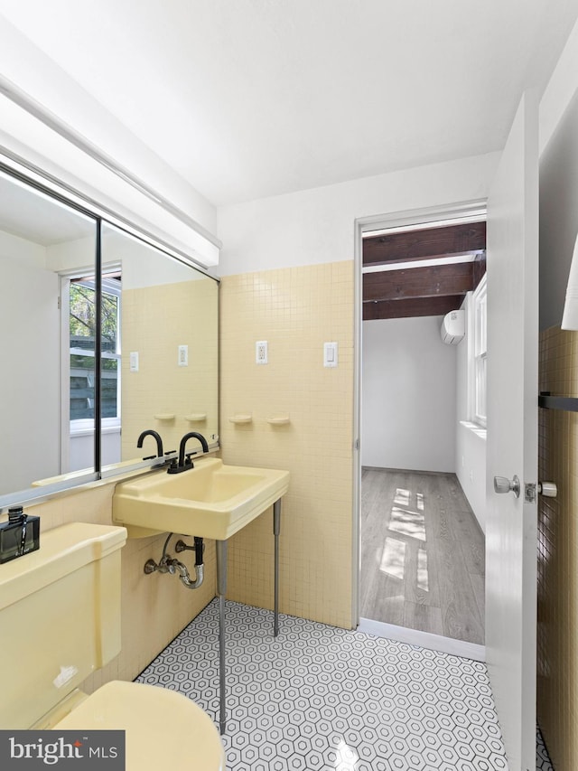 bathroom with tile walls, toilet, and wood finished floors