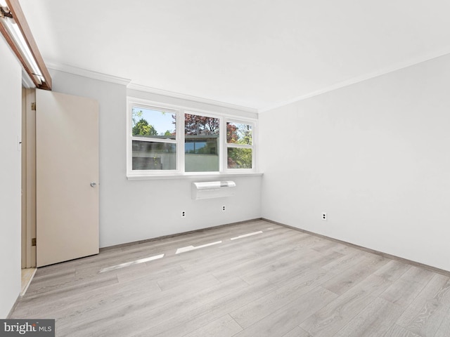 empty room with crown molding and wood finished floors