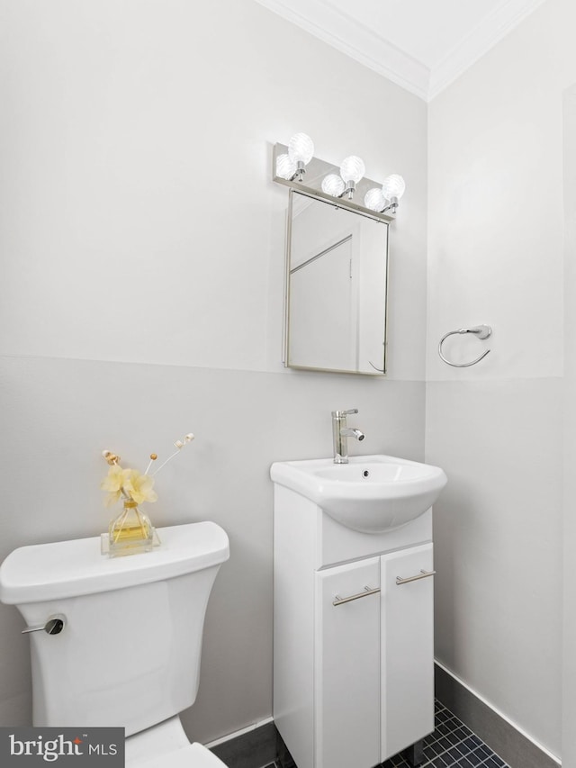 bathroom with toilet, baseboards, ornamental molding, and vanity