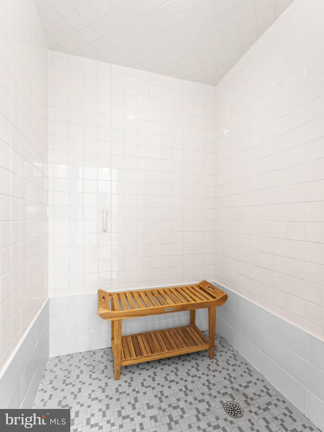 full bath with tile patterned floors, a stall shower, and tile walls