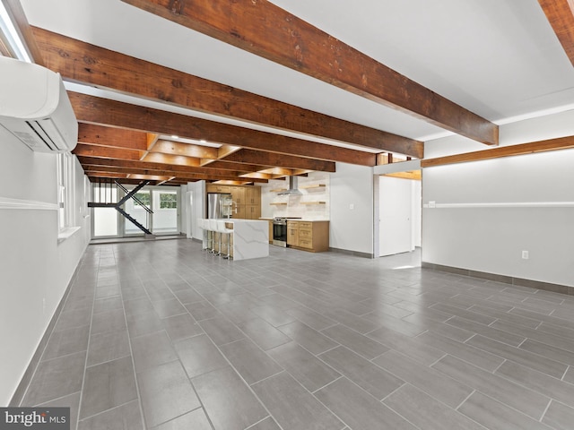 below grade area with stainless steel refrigerator with ice dispenser, baseboards, and a wall mounted air conditioner