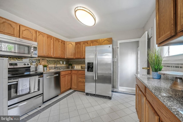 12011 Ashley Dr, Rockville, MD 20852 - kitchen with decorative backsplash, dark stone counters, appliances with stainless steel finishes, and light tile patterned flooring