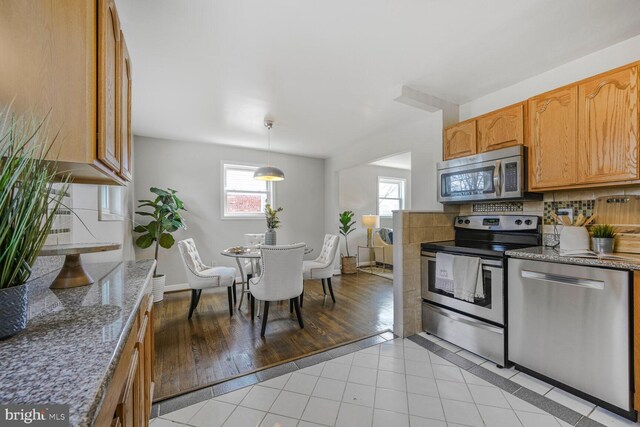 12011 Ashley Dr, Rockville, MD 20852 - kitchen featuring light stone counters, appliances with stainless steel finishes, and backsplash