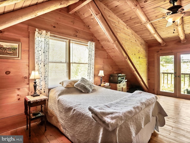 bedroom with wood walls, lofted ceiling with beams, access to exterior, and hardwood / wood-style floors