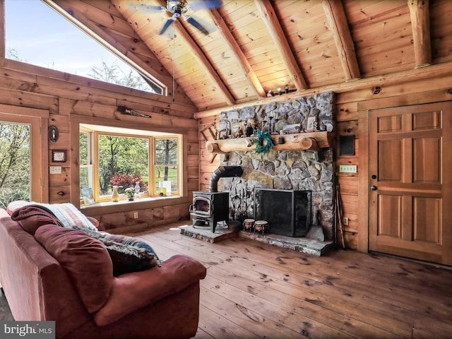 living room featuring beam ceiling, a wood stove, high vaulted ceiling, hardwood / wood-style floors, and wooden ceiling