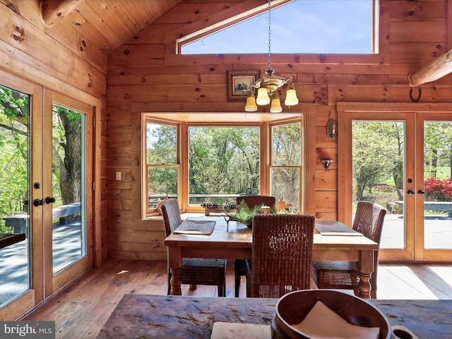 dining room featuring french doors, hardwood / wood-style flooring, a chandelier, and lofted ceiling