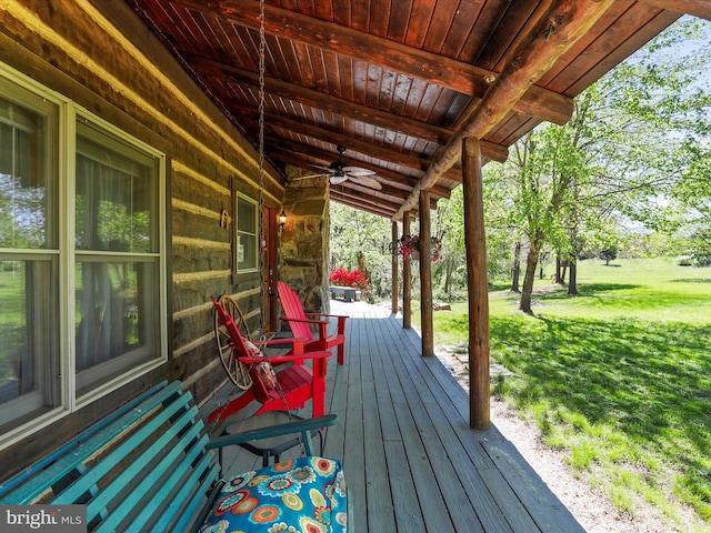 wooden deck with ceiling fan and a yard