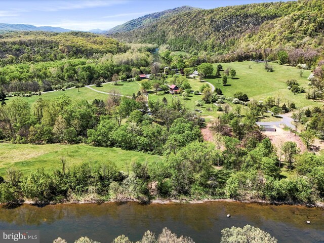drone / aerial view featuring a forest view and a water and mountain view