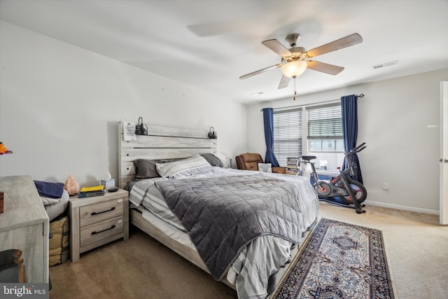 carpeted bedroom with visible vents, a ceiling fan, and baseboards