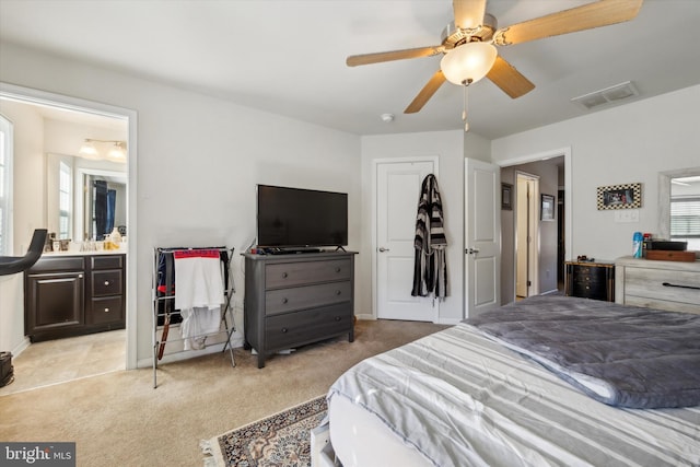 bedroom featuring connected bathroom, visible vents, ceiling fan, and light carpet