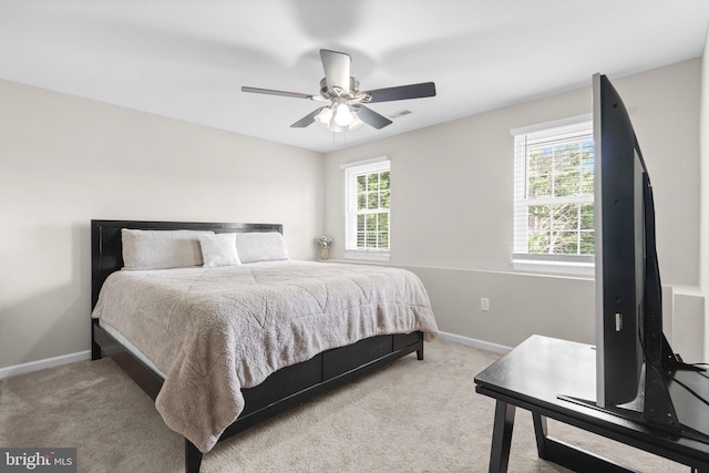 carpeted bedroom featuring multiple windows, baseboards, and ceiling fan