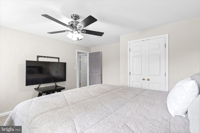 carpeted bedroom featuring a closet, ceiling fan, and baseboards