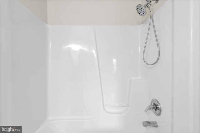 bathroom view of washtub / shower combination