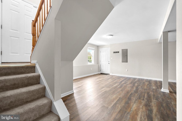 foyer entrance featuring stairs, dark wood finished floors, baseboards, and electric panel