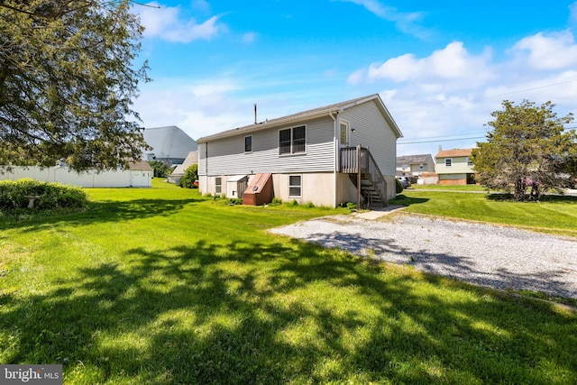 rear view of house featuring a yard and driveway