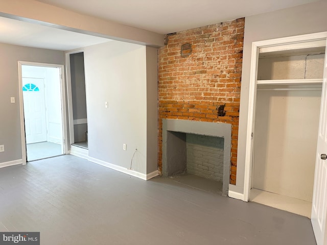 unfurnished living room with baseboards, a fireplace, and wood finished floors