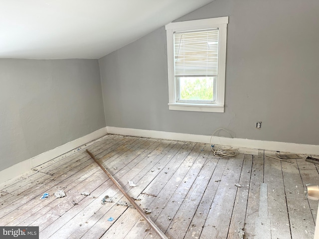 additional living space with baseboards, hardwood / wood-style floors, and lofted ceiling