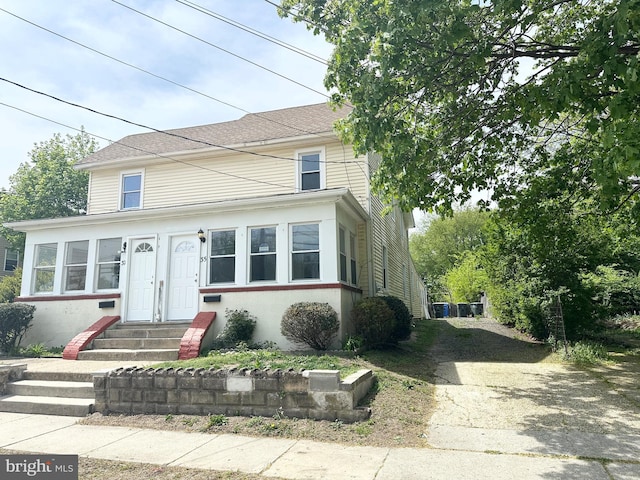 view of front of property with roof with shingles and entry steps