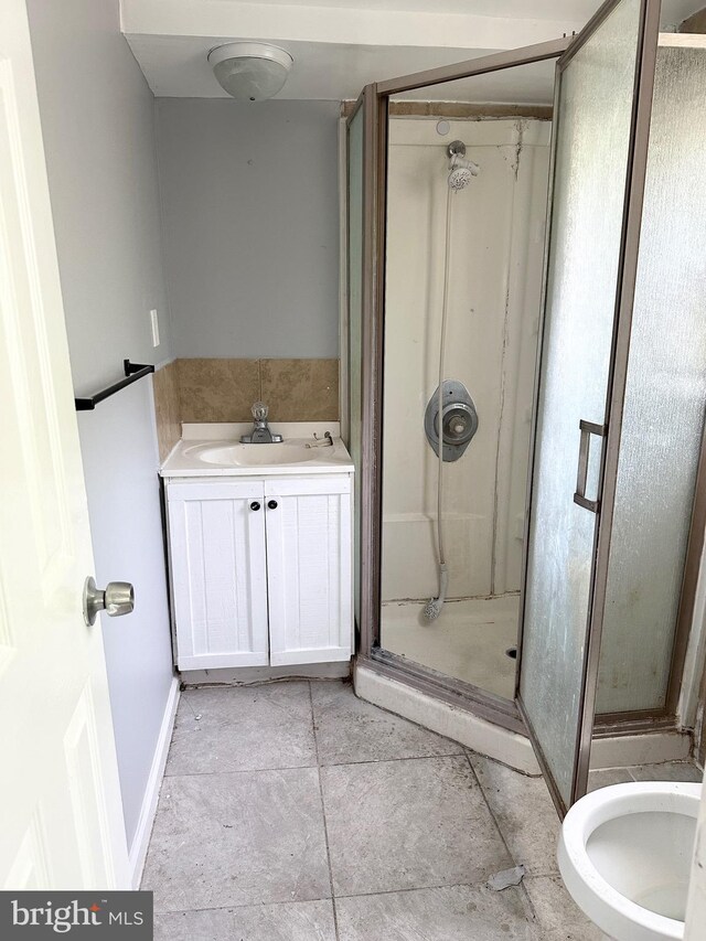 bathroom with a sink, a stall shower, and tile patterned floors