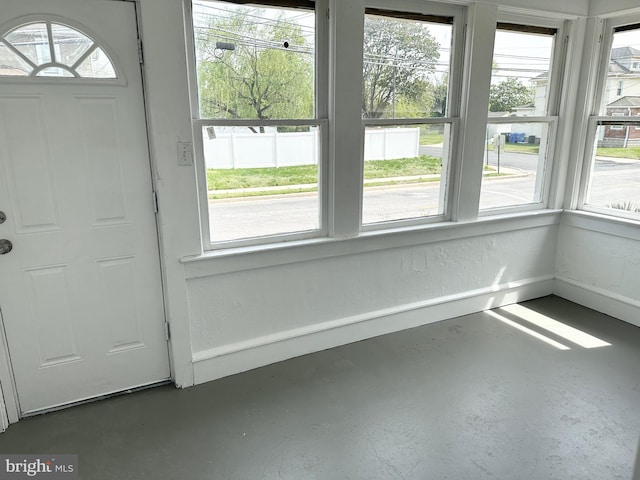 interior space with finished concrete floors and baseboards