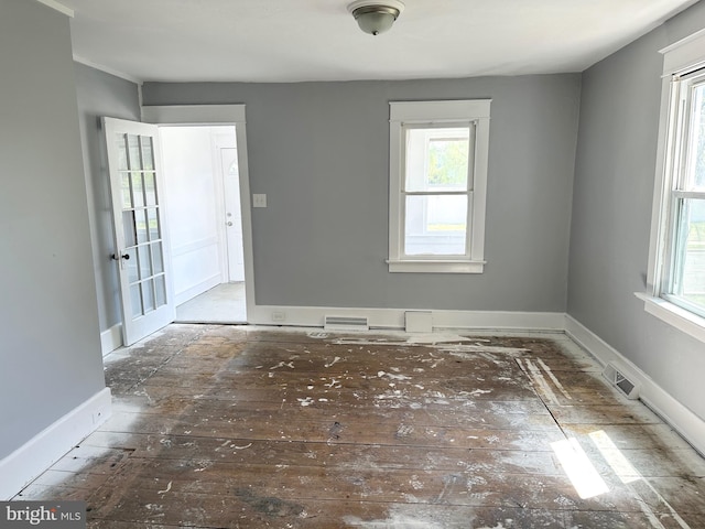 unfurnished room featuring plenty of natural light, baseboards, and visible vents