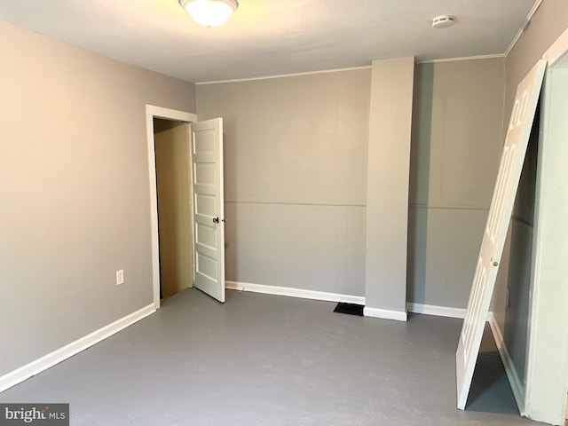 unfurnished bedroom featuring baseboards and finished concrete floors