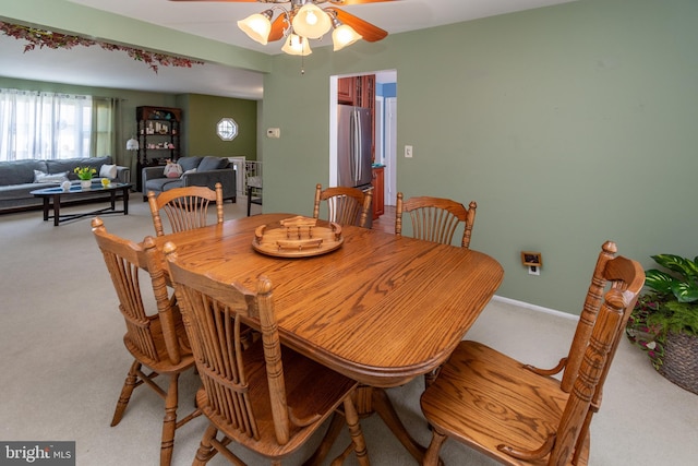 dining area featuring a ceiling fan and light colored carpet