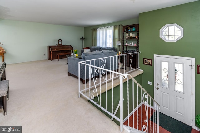 carpeted foyer with stairs