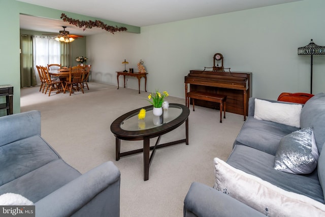 carpeted living area featuring ceiling fan
