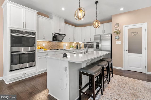 3058 Sunny Ridge Dr, Odenton, MD 21113 - kitchen featuring appliances with stainless steel finishes, a sink, dark wood-type flooring, light countertops, and tasteful backsplash