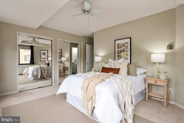 carpeted bedroom featuring baseboards, ceiling fan, and two closets