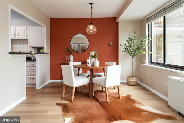 dining room with baseboards and light wood-style flooring