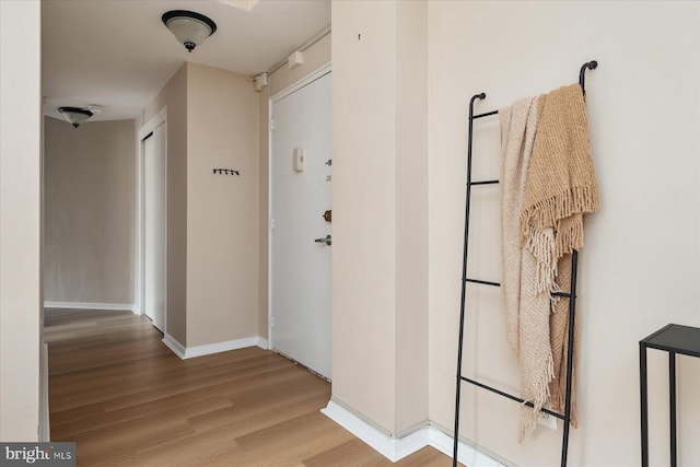 hallway with baseboards and wood finished floors