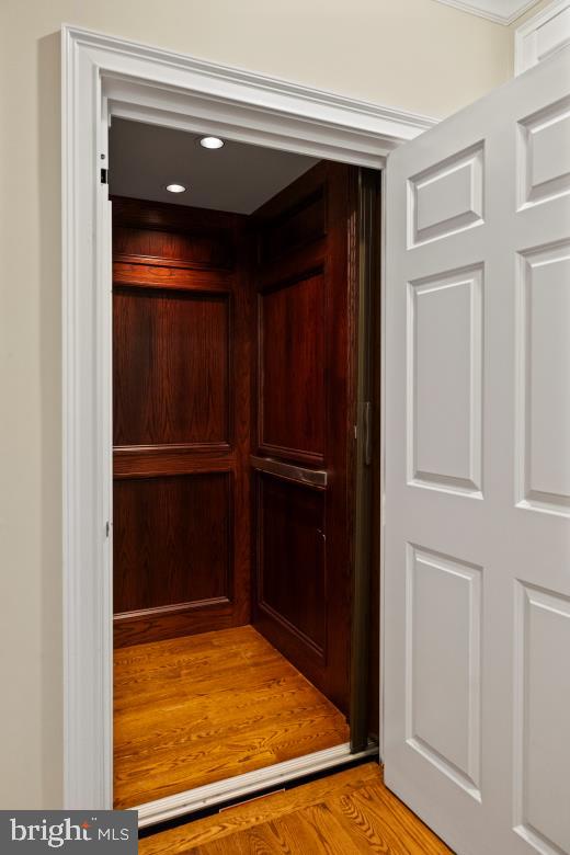details featuring recessed lighting, wood finished floors, and elevator