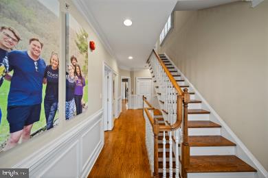 hall featuring crown molding, recessed lighting, stairway, and wood finished floors