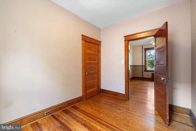 spare room featuring baseboards and light wood-type flooring
