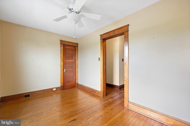 empty room with baseboards, ceiling fan, and light wood-type flooring