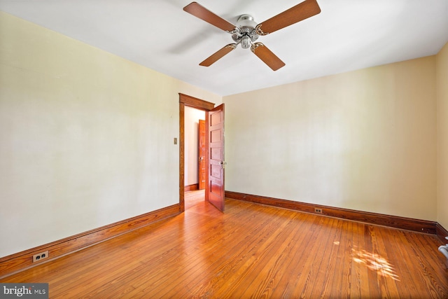 empty room featuring light wood-style floors, baseboards, and a ceiling fan