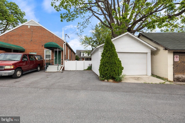 view of front facade with brick siding, fence, and driveway