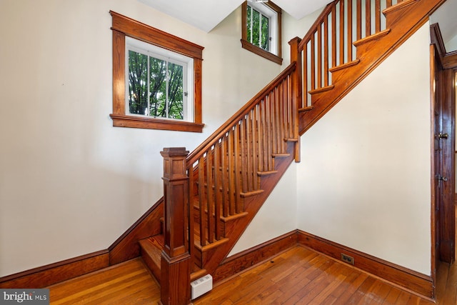 stairway featuring wood-type flooring and baseboards