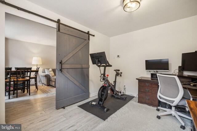 office space with a barn door and wood finished floors