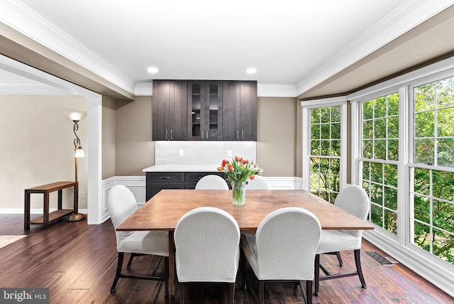 dining area featuring dark wood finished floors, ornamental molding, recessed lighting, and a wainscoted wall