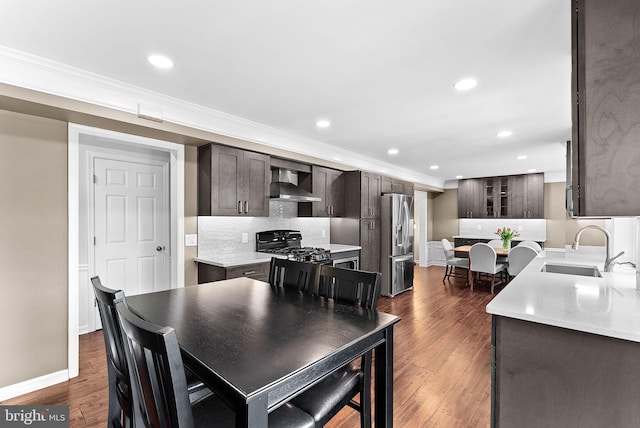 dining room featuring dark wood-type flooring, recessed lighting, ornamental molding, and baseboards