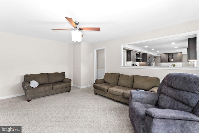 carpeted living room featuring a ceiling fan, baseboards, and recessed lighting