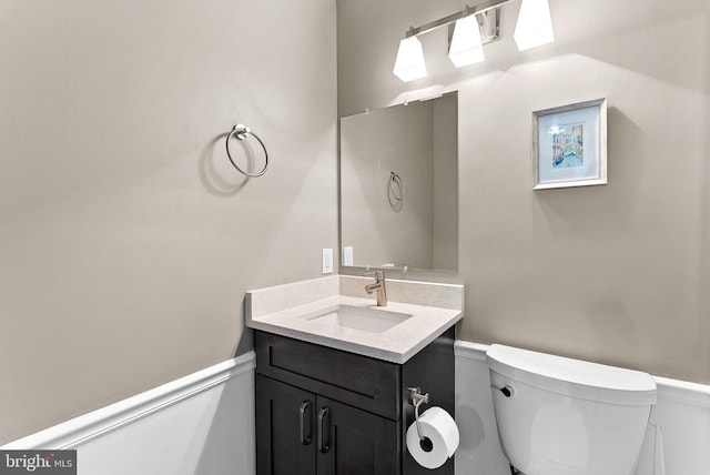 half bathroom with toilet, vanity, and a skylight
